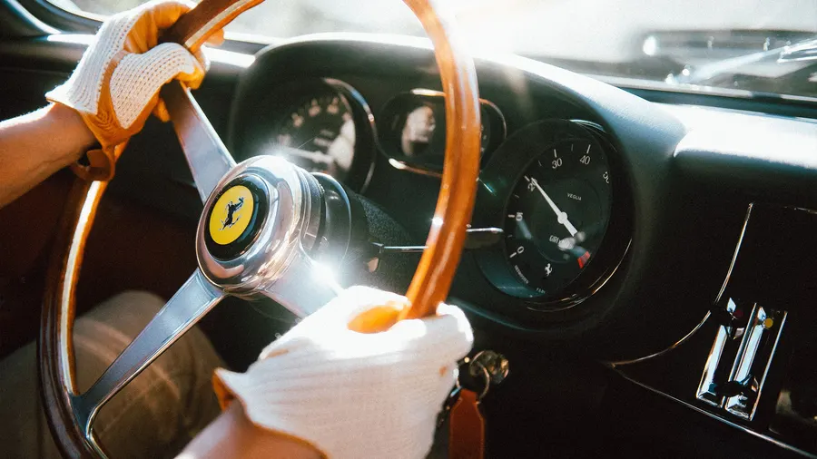 Detail of a Ferrari 275 GTB's wood-rimmed steering wheel and dashboard